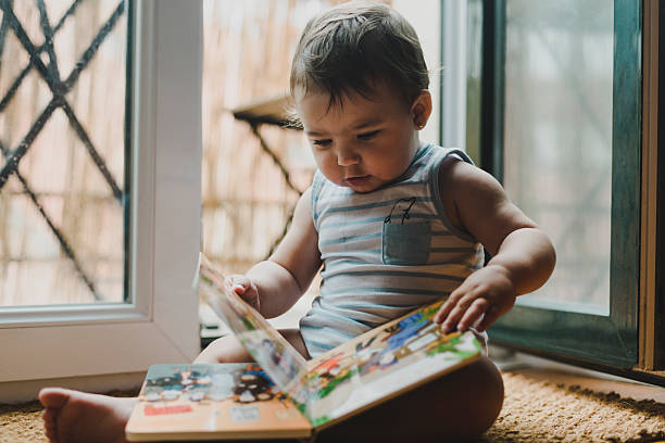 istock baby reading a colorful book 2229266042