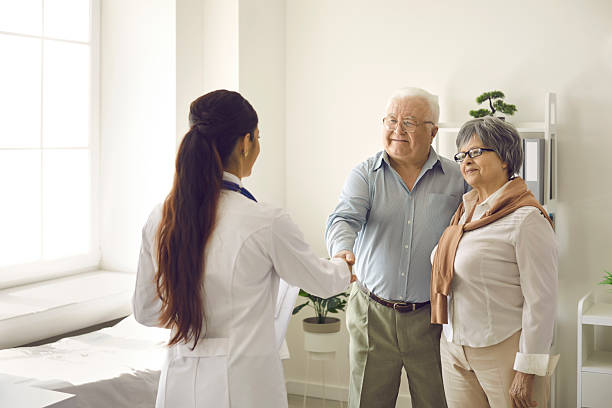 istock Happy senior couple thanking family practitioner for help and shaking hands with her 2229270611