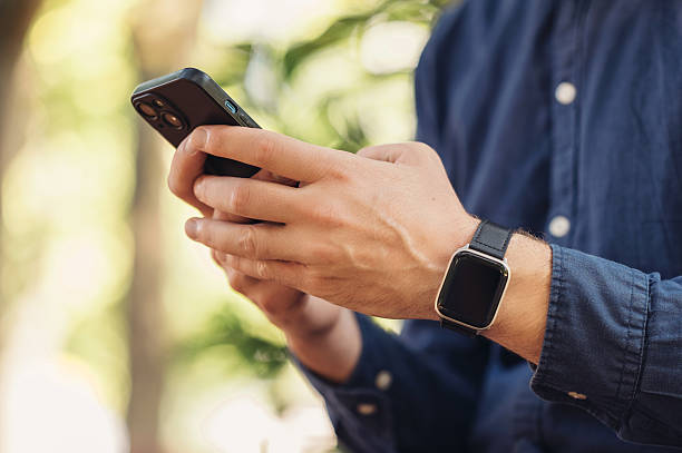istock A young man is using his smartphone while enjoying the outdoors, also wearing a smartwatch 2229272197
