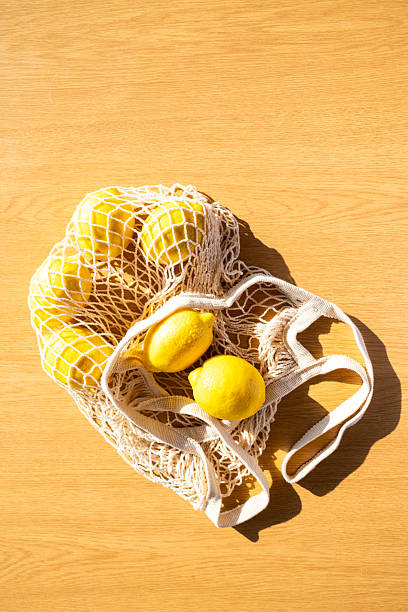 istock Fresh lemons resting in a reusable shopping bag on a wooden table 2229280489