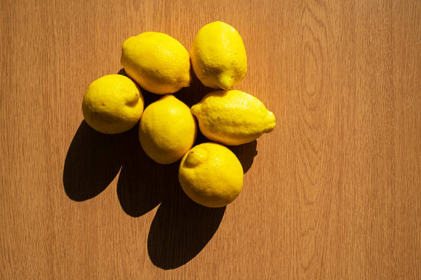 forming heart shape with fresh lemon  with gypsophila flowers on green background