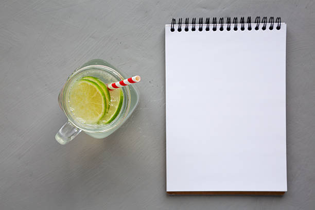 Cold Indian Nimbu Soda in a Glass Jar on a gray background, blank notepad, top view. Flat lay, overhead, from above.