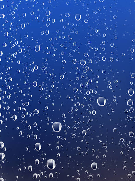 Raindrops on a window glass during a rainstorm in the evening