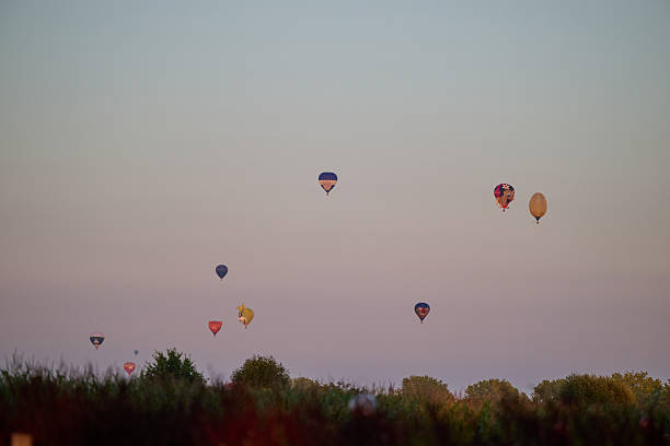 Grave , the Netherlands , international balloon festival. more than 35 hot air ballloons going in the air, view of balloons floating away in the sky