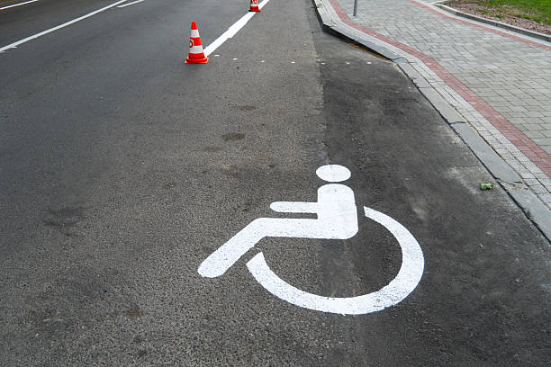 istock Accessibility symbol painted on road surface with traffic cones placed nearby in urban setting during daylight hours 2229281902