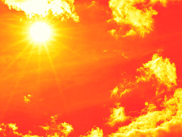 istock Bright sun with beautiful beams in the sky with clouds (toned in red) 2229282664