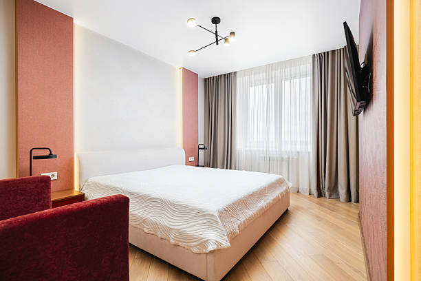 istock Modern bedroom in a stylish apartment featuring a comfortable bed, cozy seating, and bright natural light in the morning 2229286382