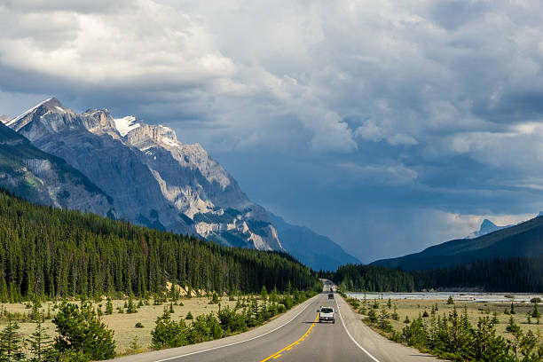 istock Car driving along Icefields Parkway toward towering Rocky Mountains 2229286423