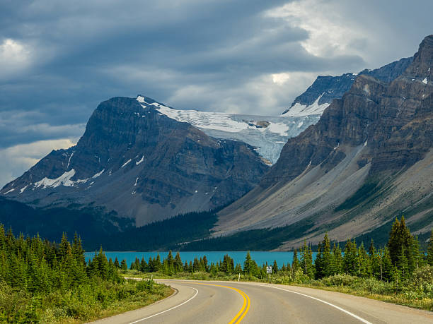 istock Car driving along Icefields Parkway toward towering Rocky Mountains 2229286425