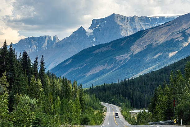 istock Car driving along Icefields Parkway toward towering Rocky Mountains 2229286427