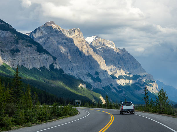 istock Car driving along Icefields Parkway toward towering Rocky Mountains 2229286431