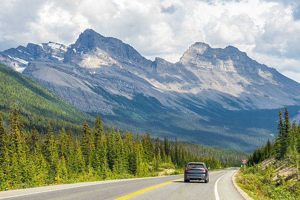 istock Car driving along Icefields Parkway toward towering Rocky Mountains 2229286439