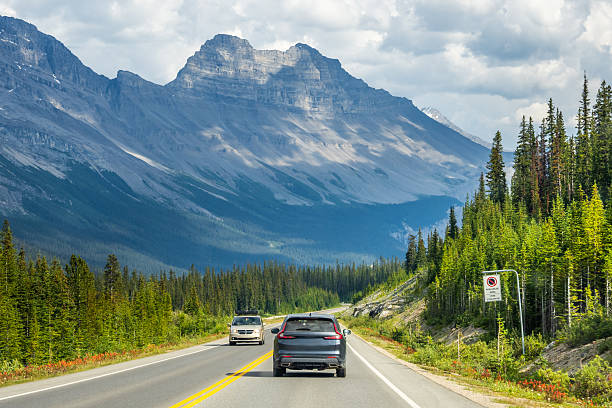 istock Car driving along Icefields Parkway toward towering Rocky Mountains 2229286440