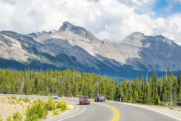istock Car driving along Icefields Parkway toward towering Rocky Mountains 2229286444