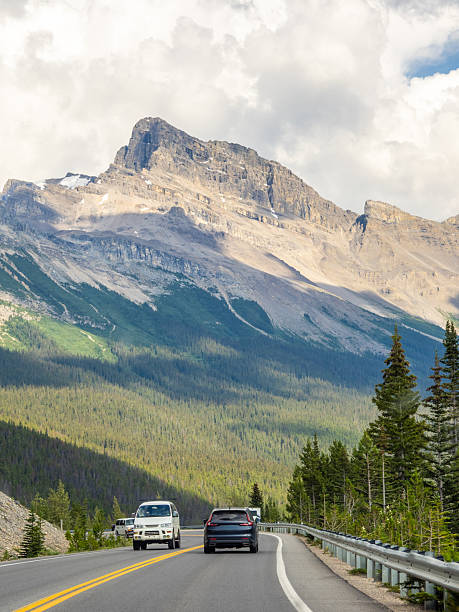 istock Car driving along Icefields Parkway toward towering Rocky Mountains 2229286445
