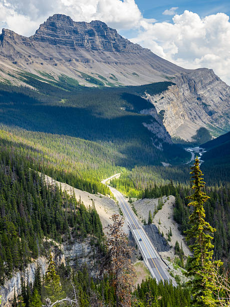 istock Car driving along Icefields Parkway toward towering Rocky Mountains 2229286447