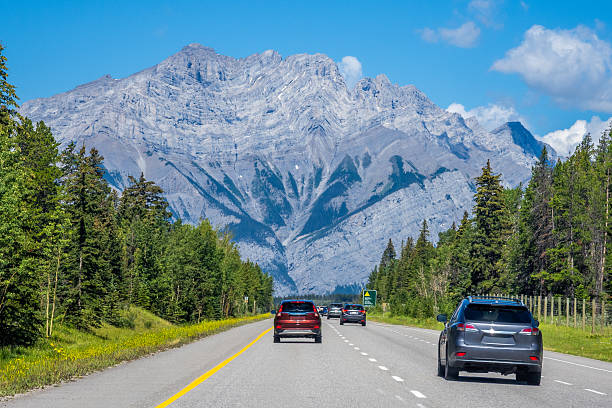 istock Car driving along Icefields Parkway toward towering Rocky Mountains 2229286451