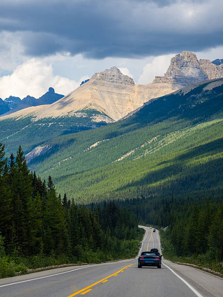 istock Car driving along Icefields Parkway toward towering Rocky Mountains 2229286460