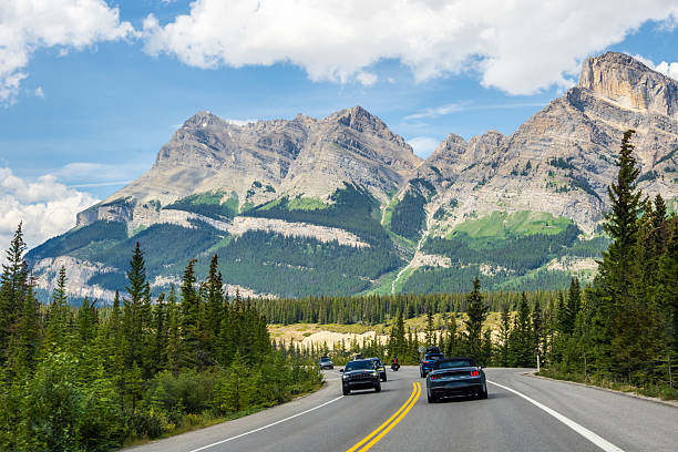 istock Car driving along Icefields Parkway toward towering Rocky Mountains 2229286463