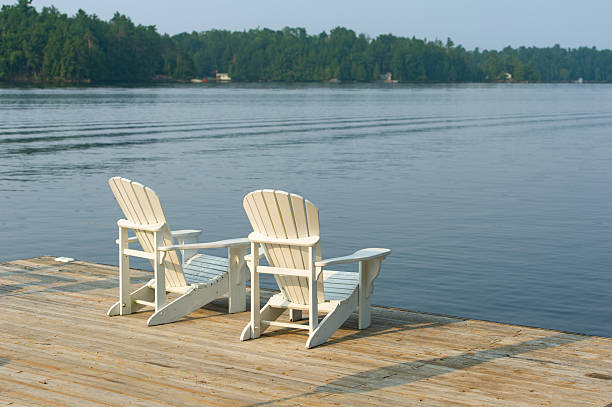 istock White chairs on a dock over a mirror-like Kawarthas lake 2229290141