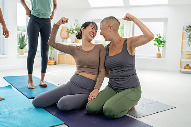 Two friends celebrating success during a yoga session in a bright studio