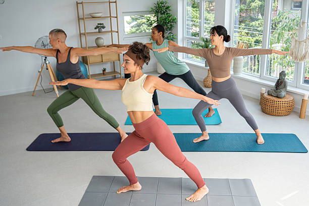 istock Group of women practicing yoga in a bright studio environment 2229300365