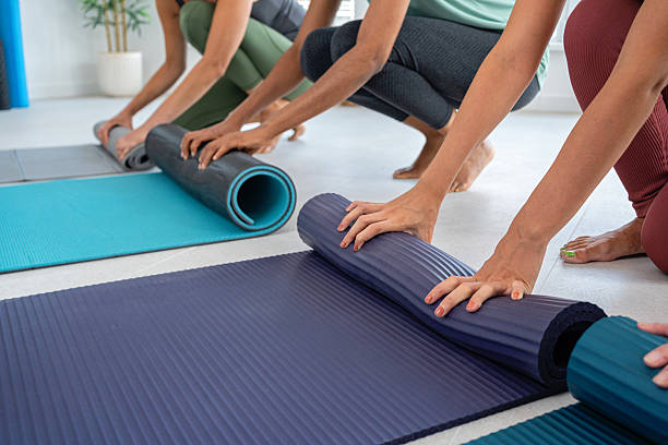 istock Women Preparing Yoga Mats in a Calm Studio Environment 2229301295