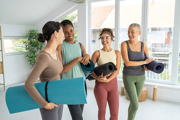 istock Four women socializing with yoga mats in a bright studio 2229301508