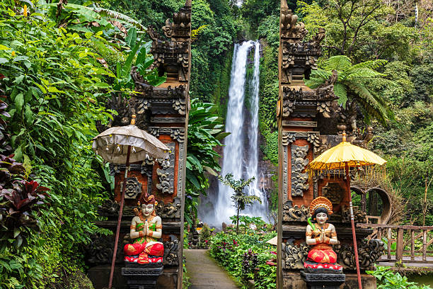 Waterfall in Bali. Statues on either side. stock photo