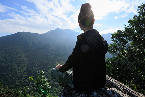 Successful hiker stand on sunrise mountain top cliff edge