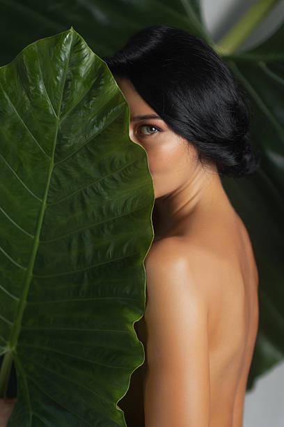 istock Mystery Woman Behind Leaf with Half Face Revealed 2229325369