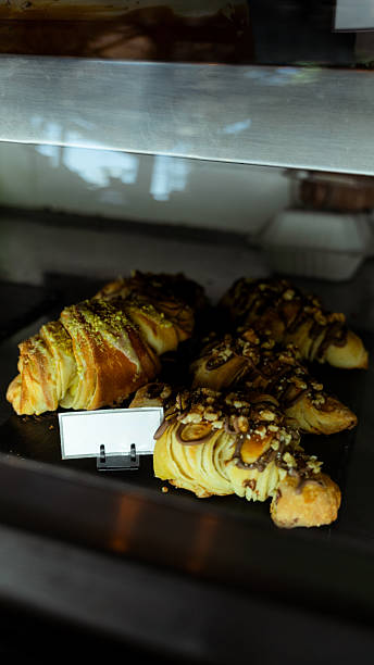 Delicious croissants with blank price tag displayed in bakery window
