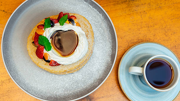 istock Delicious pancakes with whipped cream, berries, and coffee for breakfast 2229327028