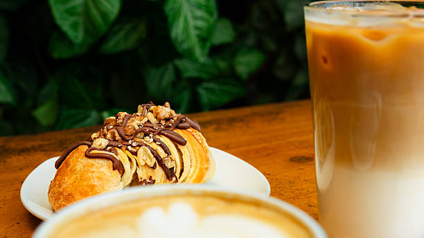 Croissant with nuts and chocolate, cappuccino and iced coffee enjoyed at a bar