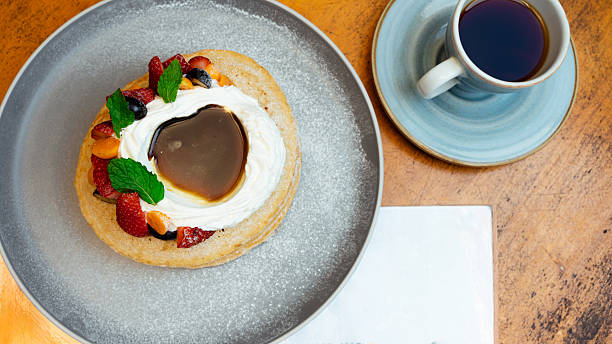 Delicious pancakes with whipped cream, berries, and coffee for breakfast