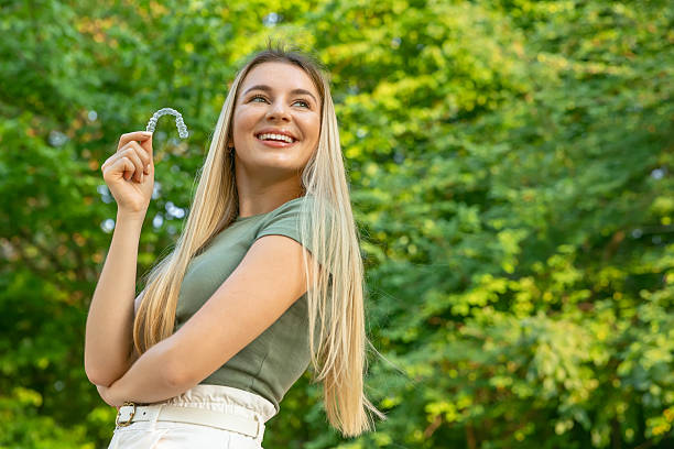 istock Smiling woman with perfect and healthy teeth using removable braces or aligner for straightening and whitening teeth. Orthodontic treatment for correction of bite. 2229330414