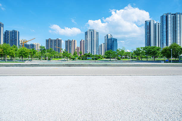 istock Empty asphalt road and modern urban skyline with sunny blue sky background 2229335372
