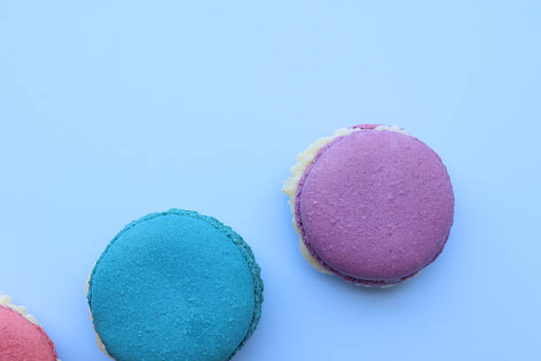 Closeup and Top view colorful macarons on a blue background. dessert cookies are both delightful and eye catching. with copy space