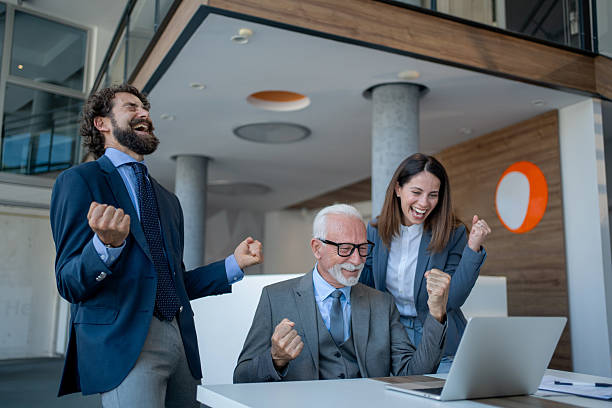 istock Business team celebrating success while looking at laptop in office 2229339527