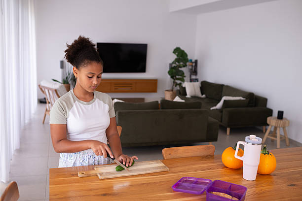 istock Young Girl Preparing Fresh Vegetables in Modern Home Kitchen. 2229343415