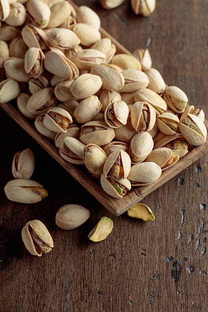 istock Salted pistachios on an old wooden table. 2229344544