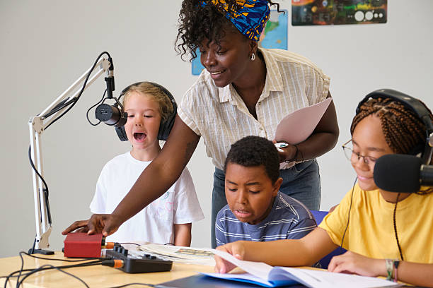 istock Teacher helping her students recording audio in a classroom 2229345148