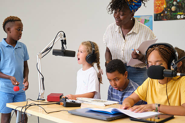 istock Elementary school students recording a podcast with their teacher 2229345175