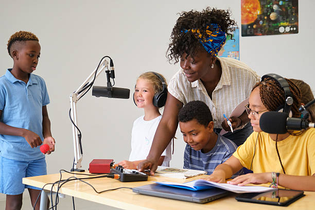 istock Elementary school students recording a podcast with their teacher 2229345201