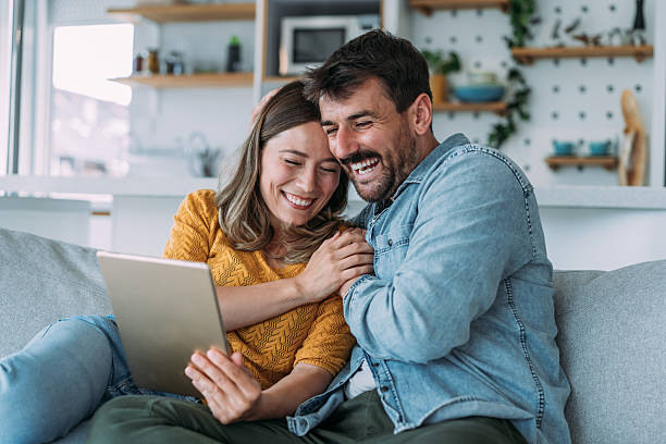istock Smiling young couple using digital tablet at home. 2229347192