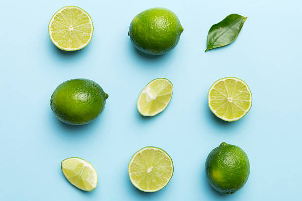 istock Lime fruits with green leaf and cut in half slice isolated on white background. Top view. Flat lay with copy space 2229351249