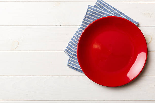 istock Top view on colored background empty round red plate on tablecloth for food. Empty dish on napkin with space for your design 2229351282