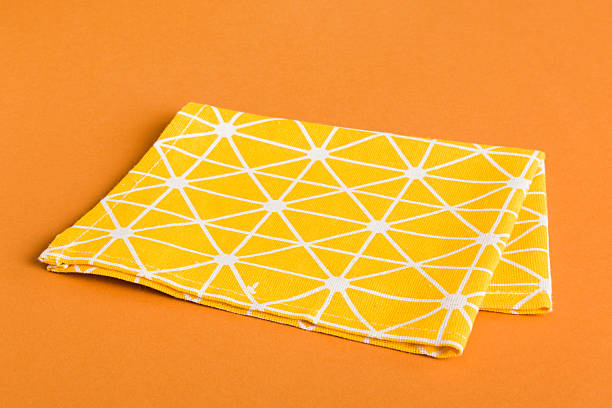 istock top view with yellow empty kitchen napkin isolated on table background. Folded cloth for mockup with copy space, Flat lay. Minimal style 2229351313