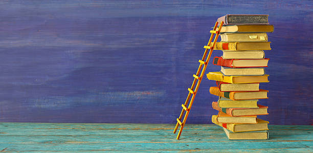 Conceptual image of a stack of books with a ladder, idea, achievements, education, knowledge,academia and success concept.Free copy space,negative space technique.