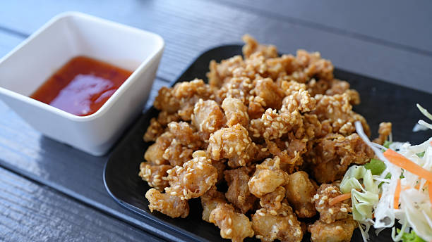 Crispy fried chicken pieces coated in sesame seeds served with sweet dipping sauce and side of fresh coleslaw. This dish offers delightful combination of textures and flavors